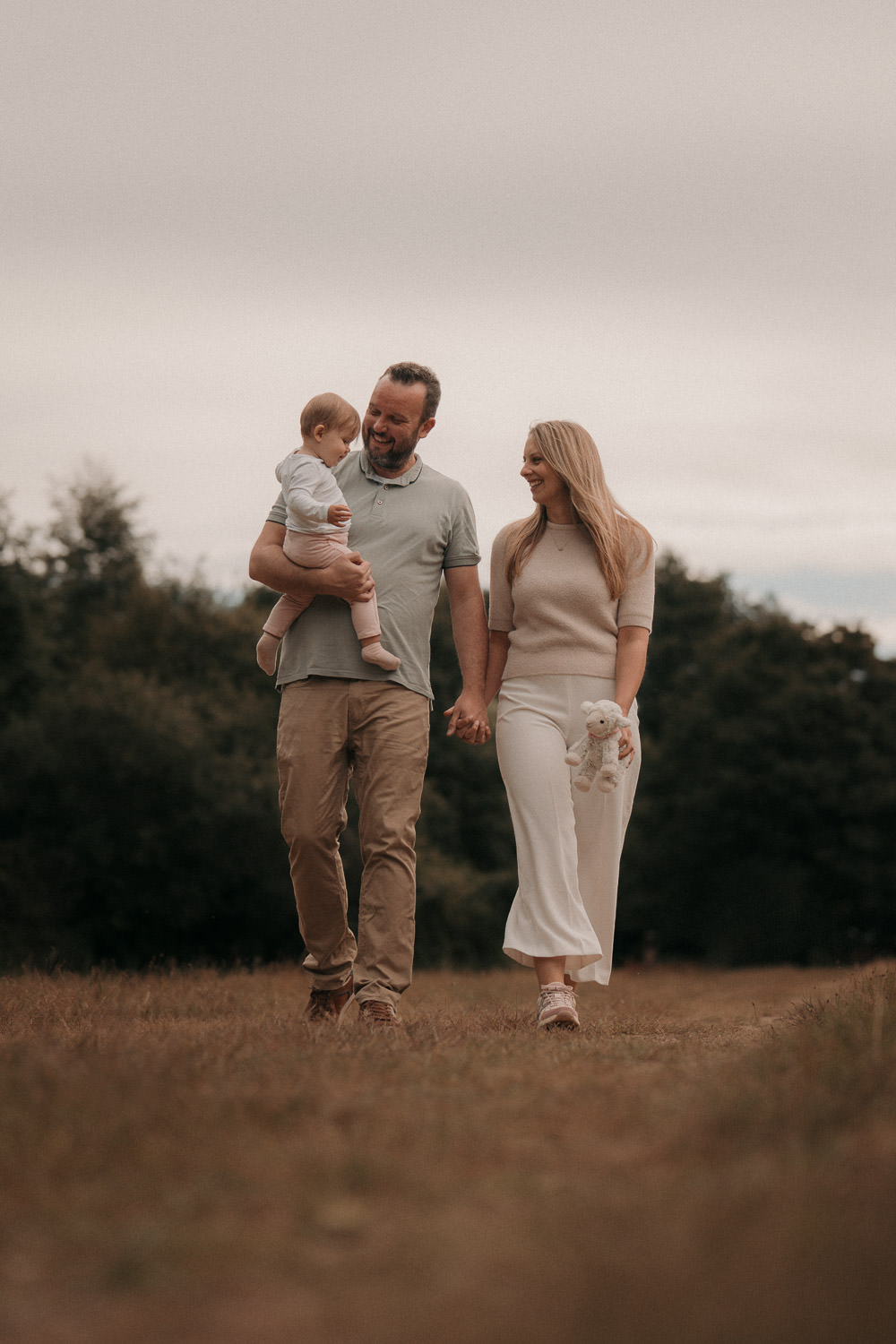 Familienshooting Frankfurt – Eltern halten ihr Baby im Arm bei einem Spaziergang durch die Natur